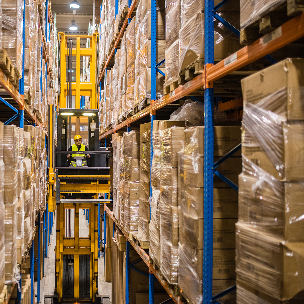 Worker in narrow isle racking system in warehouse