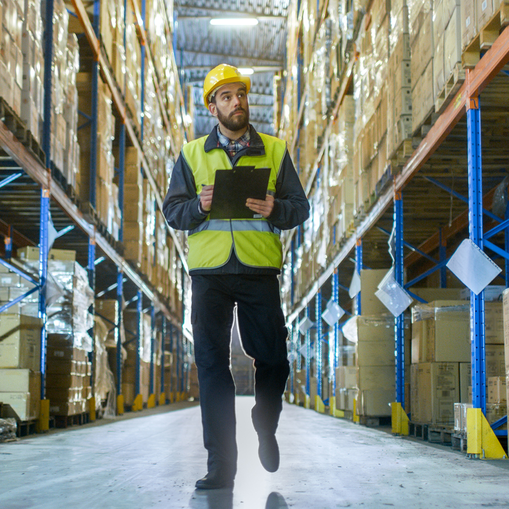 Man inspecting warehouse with clipboaerd